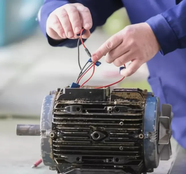 Técnico revisando las conexiones de un motor eléctrico industrial