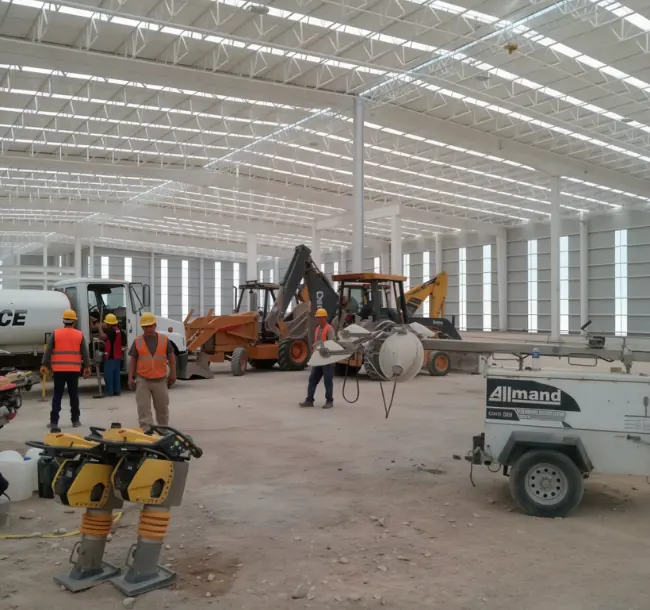 Industrial building under construction with machinery during the lighting and grounding installation